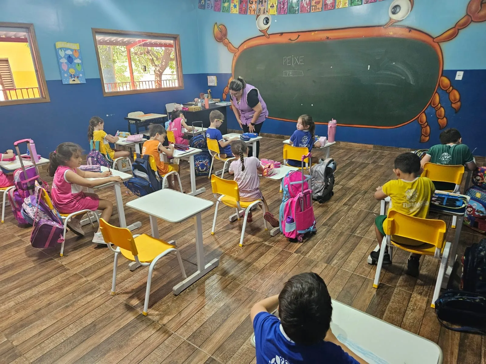 Alunos fazendo atividade em sala com lousa em formato de caranguejo